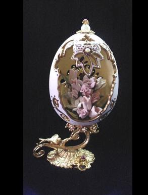 Handcrafted and painted in matte satin pink with gold enamel details. Accented w/amethyst Austrian Crystals. Decorated w/porcelain flowers in the inside. 18K gold plated stand and findings. Decorated box available for this eggypiece. 
