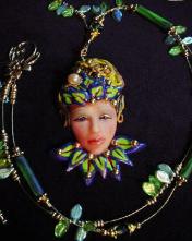 Fairy Face Green Necklace -Handmade with Polymer Clay. Findings, crimps and clasp are 14K gold plated. Gold plated Beadalon .018 in wire is also used. Glass and brass beads are used for final details. Water pearl for final detail. Unique design! 