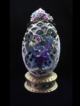  Hand carved and painted in matte pastel purple and gold enamel details. Inside, a bunch of grapes hang from the top. Glitter details and glass beads inserted in each cut. Clay stand w/glitter decoration. Decorated box available for this eggypiece. 
