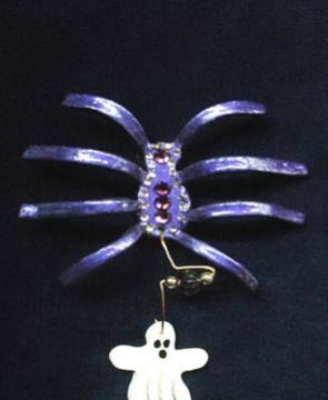 Purple Translucent Spider w/Ghost Pin-This porcelain handmade pin is painted in glossy translucent purple and accented w/Medium Amethyst Austrian Crystals. Ghost is painted in glossy pearly white. Glass beads and wire are used for final details.Unique Design!