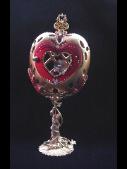 Heart Jewel Eggypiece-  Front red heart door opens. Inside, one large drop AB Austrian Crystal and red heart shaped crystal, both resting on a red velvet pillow with gold color details. This piece was imperial gold color and red satin finish. Accented with AB Austrian Crystals and red Ruby crystals. 18K gold plated stand and fidings. Decorated box available for this eggypiece.