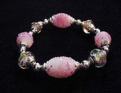 Handcrafted Jewelry Pink Glass Beads Bracelet -  Handcrafted with Pink and White  Large oval and medium round Glass beads. Transparent Lampwork pink  roses flower glass beads are used for a floral and romantic look. Embellished with Silver plated  beads and findings. Stretch cord is used for bracelet band.  Beautiful and Elegant! 