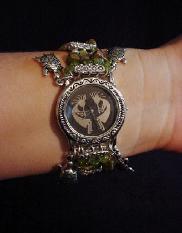 Handcrafted Semi-precious Kokopelli Watch 1 -  Handcrafted with Semi-precious Unachite and Peridot Stones. Embellished with Silver plated  beads and findings. Five turtle charms are used for final details. Stretch cord is used for watch bands. Round Large Silver watch face. Two Kokopelli's designs enhance the watch sphere. Quartz function and mechanical system. Stainless Steel back. Beautiful, Elegant and Southern look. 