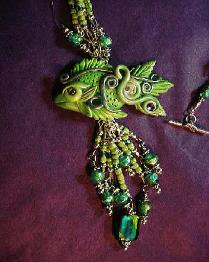 Dichroic Glass and Polymer Clay Green Fish Pendant Necklace (Close Up)- Handcrafted with Lime Green and Turquoise Blue Dichroic medium round and square large Glass beads. Czech Lime Green and Aquamarine Glass Seed Beads are used to embellish the necklace.  Silver plated  beads, fish charm, crimp tubes, final chain, clasp and findings are used for final details. Swarovski Crystals are used to accent the Polymer Clay Green Fish Pendant. Beadalon 19 flexible .018 in stringing wire is used to complete and embellish this unique creation. Beautiful and Elegant!