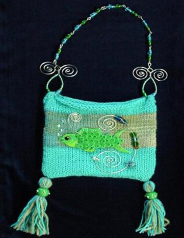 Hand-knitted with silk-wool. Decorated with a handmade Fimo Fish, glass beads and nickel wire. The fish is embellished with Austrian Crystals. Purse hanger is also handmade with nickel and glass beads. Unique design!