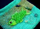 Hand-knitted with silk-wool. Decorated with a handmade Fimo Fish, glass beads and nickel wire. The fish is embellished with Austrian Crystals. Purse hanger is also handmade with nickel and glass beads. Unique design!