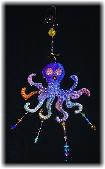 Occty the Octopus- This porcelain handmade ornament is hand-painted in translucent paints,  bright colors and black enamel details. Accented w/Medium  Amethyst Austrian Crystals and embellished w/glass beads. Gold color wire is used for final and hanging details. Unique Design!