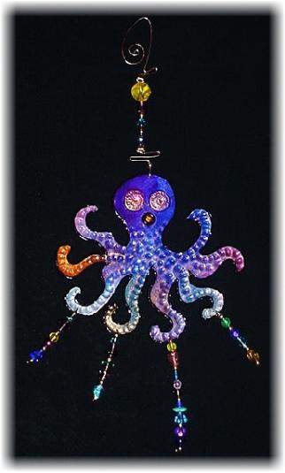 This porcelain handmade ornament is hand-painted in translucent paints,  bright colors and black enamel details. Accented w/Medium  Amethyst Austrian Crystals and embellished w/glass beads. Gold color wire is used for final and hanging details. Unique Design!