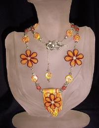 Orange and Yellow Flowery Necklace-Handmade Polymer Clay  Orange and Yellow beads.Handcrafted with Sterling Silver wire, crimps, chains and findings. Beadalon .018 in/19 stringing wire is also used.Embellished with fresh water pearls, crackle beads and Austrian crystals bicone beads for final details.Beautiful and unique for that special occasion.