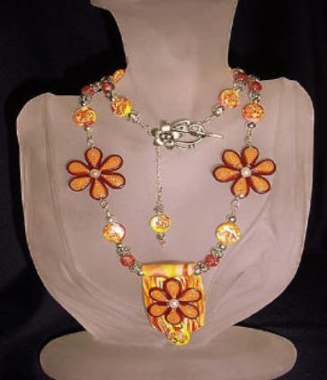  Orange and Yellow Flowery Necklace-Handmade Polymer Clay  Orange and Yellow beads. Handcrafted with Sterling Silver wire, crimps, chains and findings. Beadalon .018 in/19 stringing wire is also used. Embellished with fresh water pearls, crackle beads and Austrian crystals bicone beads for final details.Beautiful and unique for that special occasion.