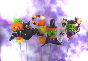 Polymer Halloween Food Picks - These unique handmade food picks will be the focal point in your party!BOO!! Handmade with polymer clay and decorated with glass beads, austrian crystals and wire. Each pick is aprox.6 in height , brass finished and washable. The set comes in a wooden handpainted base. Each set/6 comes in a clear PVC box for presentation. More seasonal designs will be available soon!