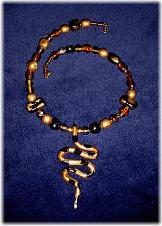 This clay handmade necklace is hand-painted in antique gold, black and copper colors. Accented w/blown glass beads, metal and clay handmade beads. The snake is handmade with clay. Gold plated wire and findings are  used for final details. Unique Design and Very wild!