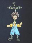 The Hanger People Boy- These porcelain handmade ornaments are painted in translucent light pink, bright pink, blue and other bright colors. Also, black and white colors are used for final details. A unique design handmade hanger w/metal and glass beads are used for final details. Unique design, one-of-a-kind ! 100% handmade