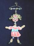 The Hanger People Girl- These porcelain handmade ornaments are painted in translucent light pink, bright pink, blue and other bright colors. Also, black and white colors are used for final details. A unique design handmade hanger w/metal and glass beads are used for final details. Unique design, one-of-a-kind ! 100% handmade