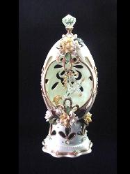 Innocent Unicorn Eggypiece- Painted in lime green satin color and gold enamel details. Inside, a glass unicorn miniature w/24K gold plated details. Accented with Austrian Crystals and decorated with yellow and white porcelain roses. Mirror on the bottom of unicorn and stand in clay w/glitter and beads details. Decorated box available for this eggypiece. 