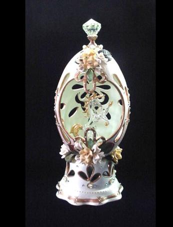 Painted in lime green satin color and gold enamel details. Inside, a glass unicorn miniature w/24K gold plated details. Accented with Austrian Crystals and decorated with yellow and white porcelain roses. Mirror on the bottom of unicorn and stand in clay w/glitter and beads details. Decorated box available for this eggypiece. 