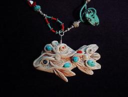 Handcrafted White Fish and Turquoise Necklace- Fish pendant handmade with polymer clay and embellished with Sleeping Beauty Turquoise Cabs. Fiber optic Orange and Mother of Pearls Beads are also used. Sterling Silver Bali Beads and findings. Turquoise medium doughnut is used as a clasp.Unique design! 