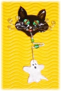 This porcelain handmade pin is painted in glossy black. Ghost is painted in pearly white. Topaz Austrian Crystals and oval shape glass beads are used for the eyes. Whiskers are made of wire. Glass and metal  beads are used for final details. Unique Design!